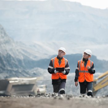 Two speacialists examining coal at an open pit